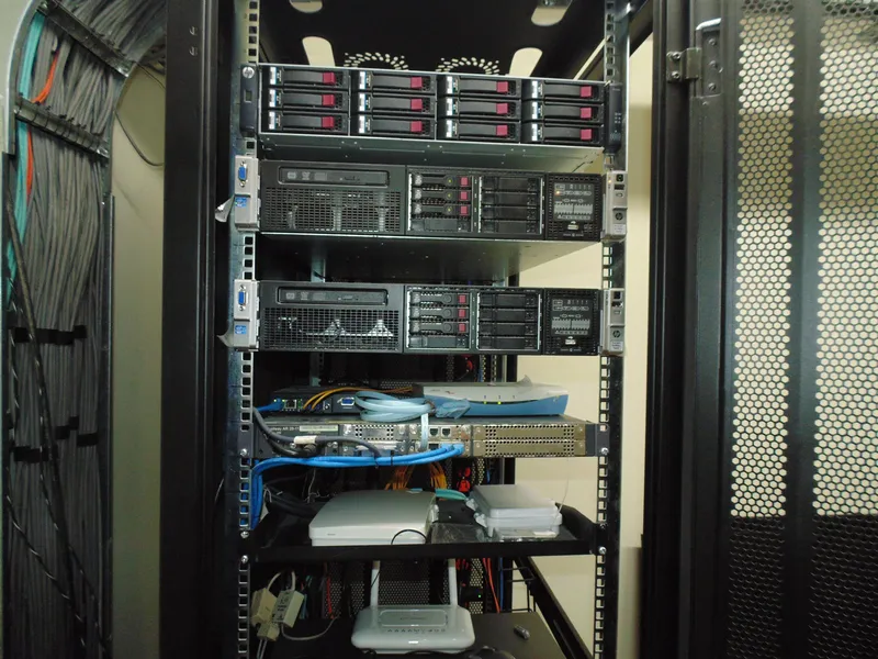 Rack de servidores HP ProLiant con arreglo de discos, switches, router y fibra óptica